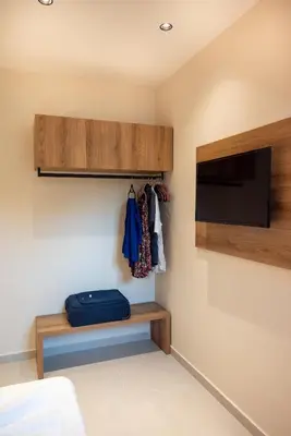 a bedroom with a tv and a shelf and a bed at Mystrali I in Galatás