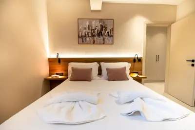 a bedroom with a white bed with two towels on it at Mystrali I in Galatás