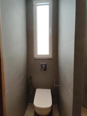 a bathroom with a white toilet with a window at Apartment Near Beach & Old Port in Chania Town