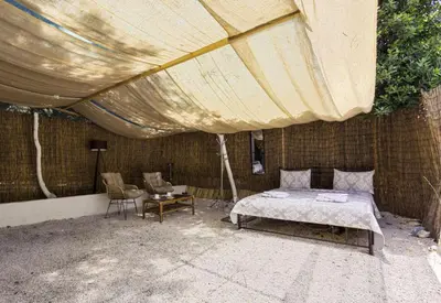 a bed under a tent with a table and chairs at Edem private camping in Análipsis