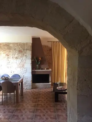 a living room with a table and a fireplace at Despoinas House in Kounoupidhianá