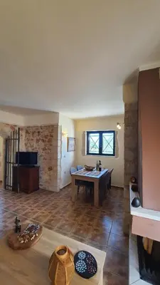 a living room with a table in the middle of it at Despoinas House in Kounoupidhianá