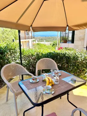 a table with a tea set on it under an umbrella at Despoinas House in Kounoupidhianá