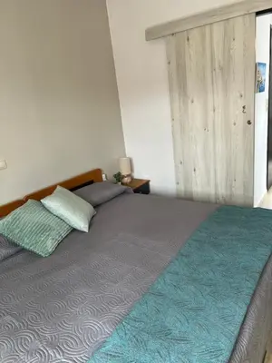 a bedroom with a large bed with a blue blanket at Azure Sea Bliss at The Erodios Apartments in Kalyves