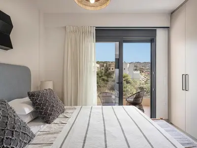 a bedroom with a large bed and a large window at Iris Luxury Apartment in Chania Town