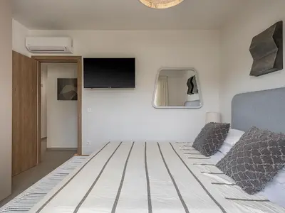 a bedroom with a bed with a tv on the wall at Iris Luxury Apartment in Chania Town
