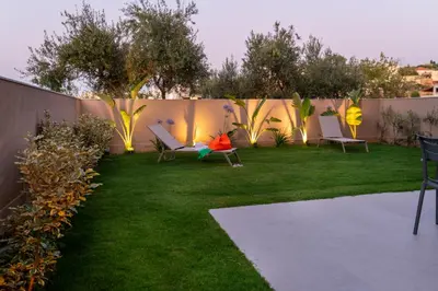 a yard with chairs and a fence with lights at Mystrali II in Galatás