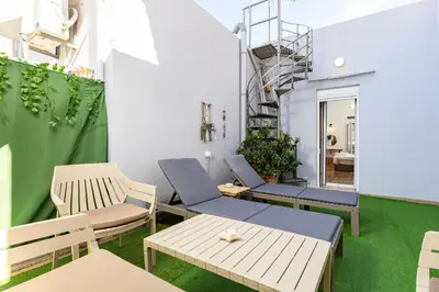 a room with chairs and tables and a staircase at Sea & City - Luxury Maisonette Steps from the Beach with Private Terrace in Chania Town