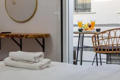 a hotel room with a table with a chair and towels at Sea & City - Luxury Maisonette Steps from the Beach with Private Terrace in Chania Town