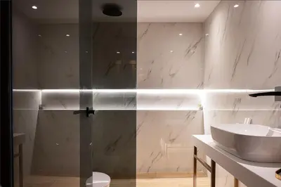 a bathroom with a sink and a glass shower door at Orus Villa in Chania Town
