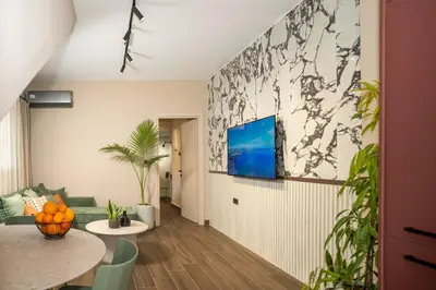 a living room with a table and a tv on a wall at Panterra-Chania Center in Chania Town