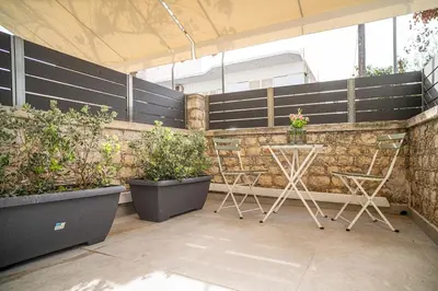 a patio with two chairs and some potted plants at Panterra-Chania Center in Chania Town