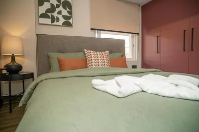 a bedroom with a green bed with towels on it at Panterra-Chania Center in Chania Town