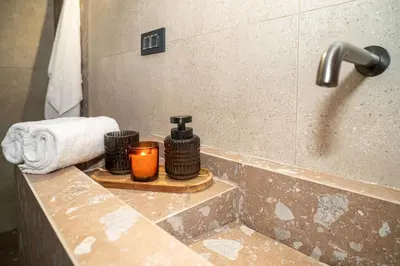 a bathroom counter with a bottle of soap and a candle at Panterra-Chania Center in Chania Town