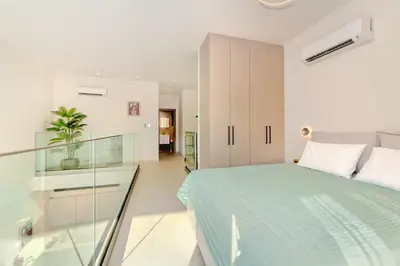 a bedroom with a bed and a glass wall at Lavender Loft in Chania Town
