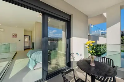 a room with glass doors and a table with a vase of flowers at Lavender Loft in Chania Town