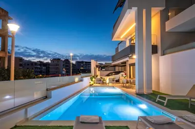 a swimming pool on the roof of a house at night at Lavender Loft in Chania Town