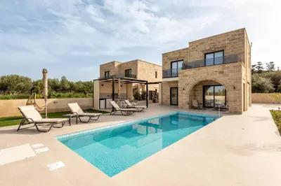 a villa with a swimming pool and a house at Golden Silence in Plataniás
