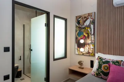 a bedroom with a bed and a mirror and a window at Golden Silence in Plataniás