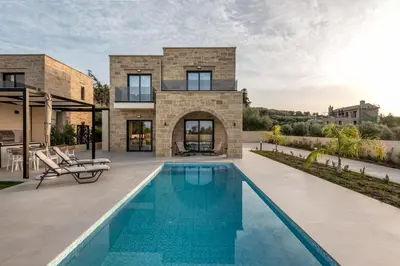 a house with a swimming pool in front of it at Golden Silence in Plataniás