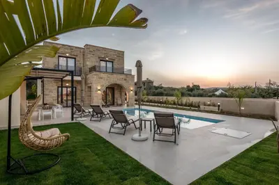 a villa with a swimming pool and a patio at Golden Silence in Plataniás