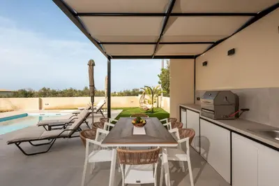 a kitchen and dining room with a table and chairs at Golden Silence in Plataniás