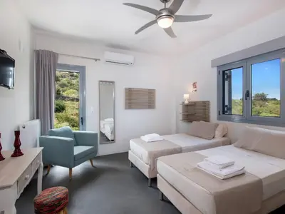 a living room with two beds and a couch at Holiday Home Villa vacanze Agave Creta con piscina privata by Interhome in Litsárdha
