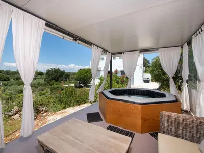 a room with a soaking tub in the middle of a window at Holiday Home Villa vacanze Agave Creta con piscina privata by Interhome in Litsárdha