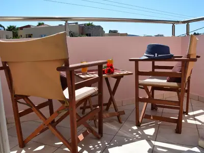 a table and two chairs and a table on a balcony at Apartment Charmante Ferienwohnung Rubini 2 by Interhome in Agia Marina Nea Kydonias
