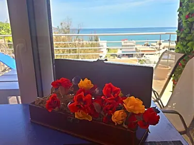 a box of flowers on a table with a view of the ocean at Apartment Moderne Wohnung Rubini 3 by Interhome in Chania Town