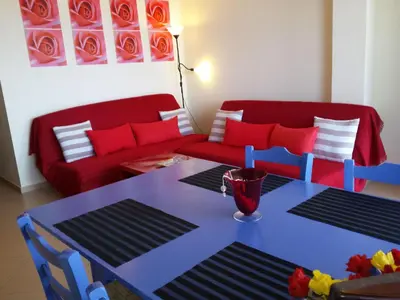 a living room with a table and a red couch at Apartment Moderne Wohnung Rubini 3 by Interhome in Chania Town