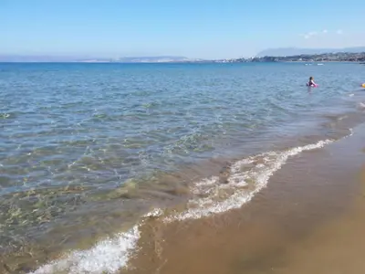 a person standing in the water at the beach at Apartment Moderne Wohnung Rubini 3 by Interhome in Chania Town