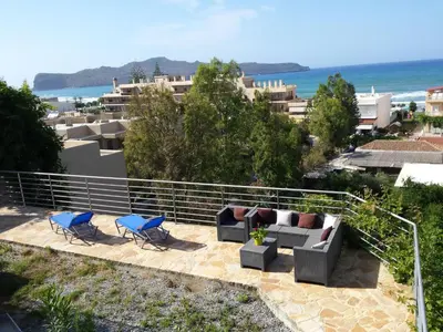a patio with couches and chairs and the ocean at Apartment Rubini 1 by Interhome in Agia Marina Nea Kydonias