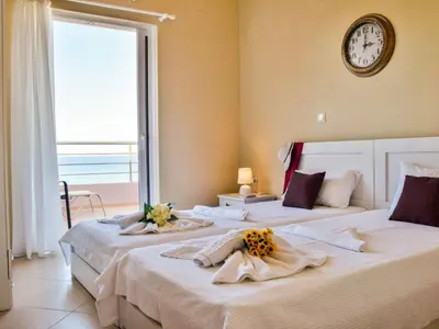 two beds in a room with a clock on the wall at Apartment Rubini 1 by Interhome in Agia Marina Nea Kydonias