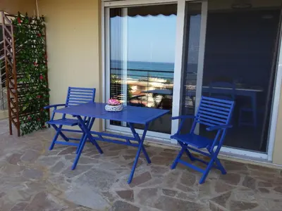 a blue table and chairs on a balcony with the ocean at Apartment Gemütliche Ferienwohnung Rubini 4 by Interhome in Agia Marina Nea Kydonias