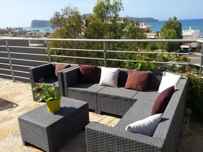 a patio with two couches and a table with a plant at Apartment Gemütliche Ferienwohnung Rubini 4 by Interhome in Agia Marina Nea Kydonias