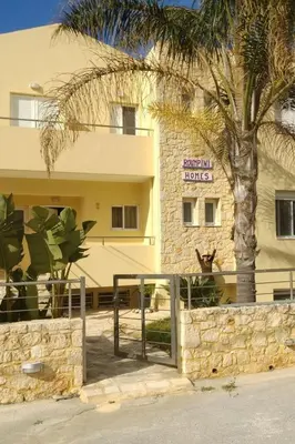a hotel with a palm tree in front of a building at Apartment Gemütliche Ferienwohnung Rubini 4 by Interhome in Agia Marina Nea Kydonias