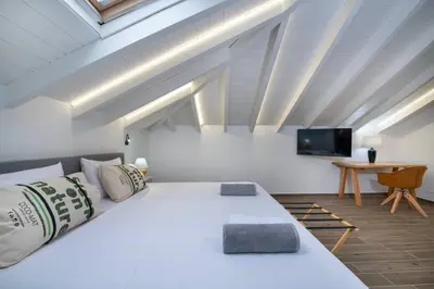 a bedroom with a large white bed and a tv at Chania Luxury City Retreat , Hammam & outdoor Jacuzzi in Chania Town