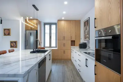 a kitchen with white counter tops and wooden cabinets at Chania Luxury City Retreat , Hammam & outdoor Jacuzzi in Chania Town