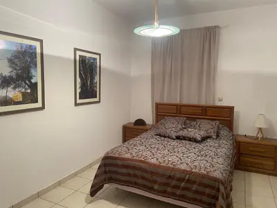 a bedroom with a bed and a lamp and a window at Ellie's Kantanos in Kántanos