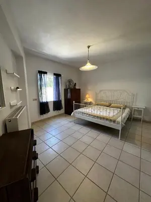 a bedroom with a bed and a tiled floor at Ellie's Kantanos in Kántanos