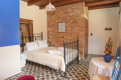 a bedroom with a bed and a brick wall at Stone-Built Traditional Villa with Pool in Sfakia in Ímbros