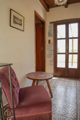 a room with a table and a chair and a door at Stone-Built Traditional Villa with Pool in Sfakia in Ímbros