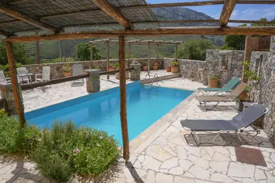 a swimming pool with chairs and a pergola at Stone-Built Traditional Villa with Pool in Sfakia in Ímbros
