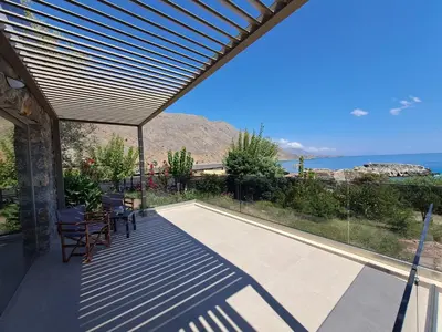a patio with chairs and a view of the ocean at Castella Luxe in Loutro