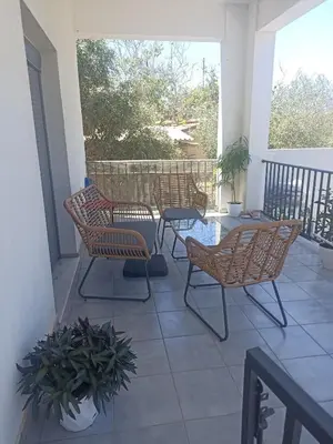 a patio with chairs and a table on a porch at Ifigenias House in Kissamos