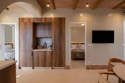 a living room with a television and a room with a bed at Raviewha Luxury Apartments 3 in Ravdhoúkha