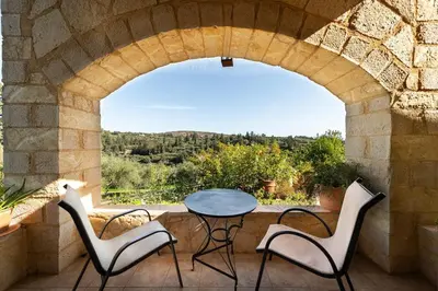 a patio with a table and chairs and a window at Villa Levedeli in Nerokhórion