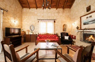 a living room with a red couch and a fireplace at Villa Levedeli in Nerokhórion