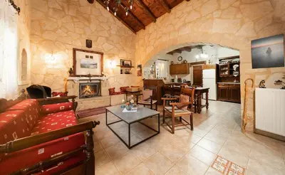 a living room with a couch and a table and a kitchen at Villa Levedeli in Nerokhórion